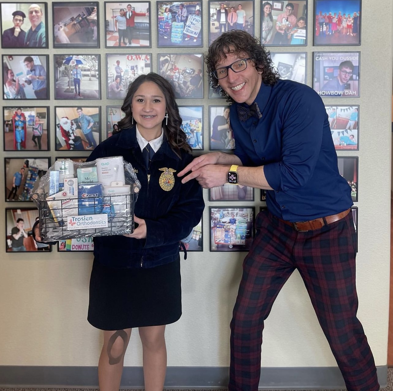 Dr Trosien pointing at woman holding a basket full of orthodontics supplies