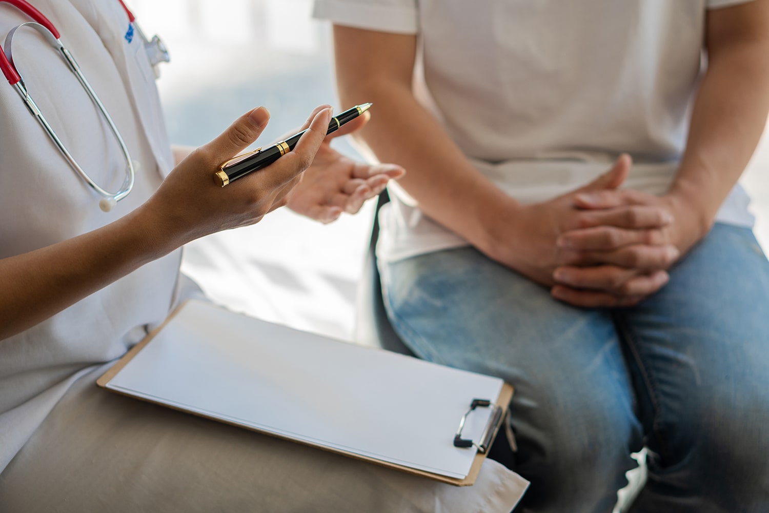 Dental patient and staff discussing appointment details, focus on hands at center profile