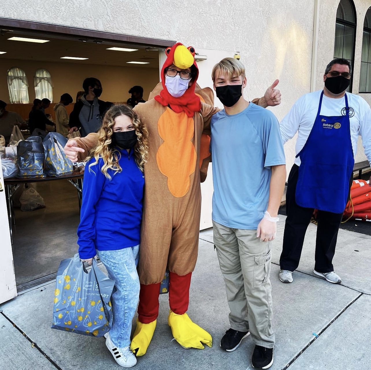 Dr Trosien dressed in a turkey costume with two teenagers