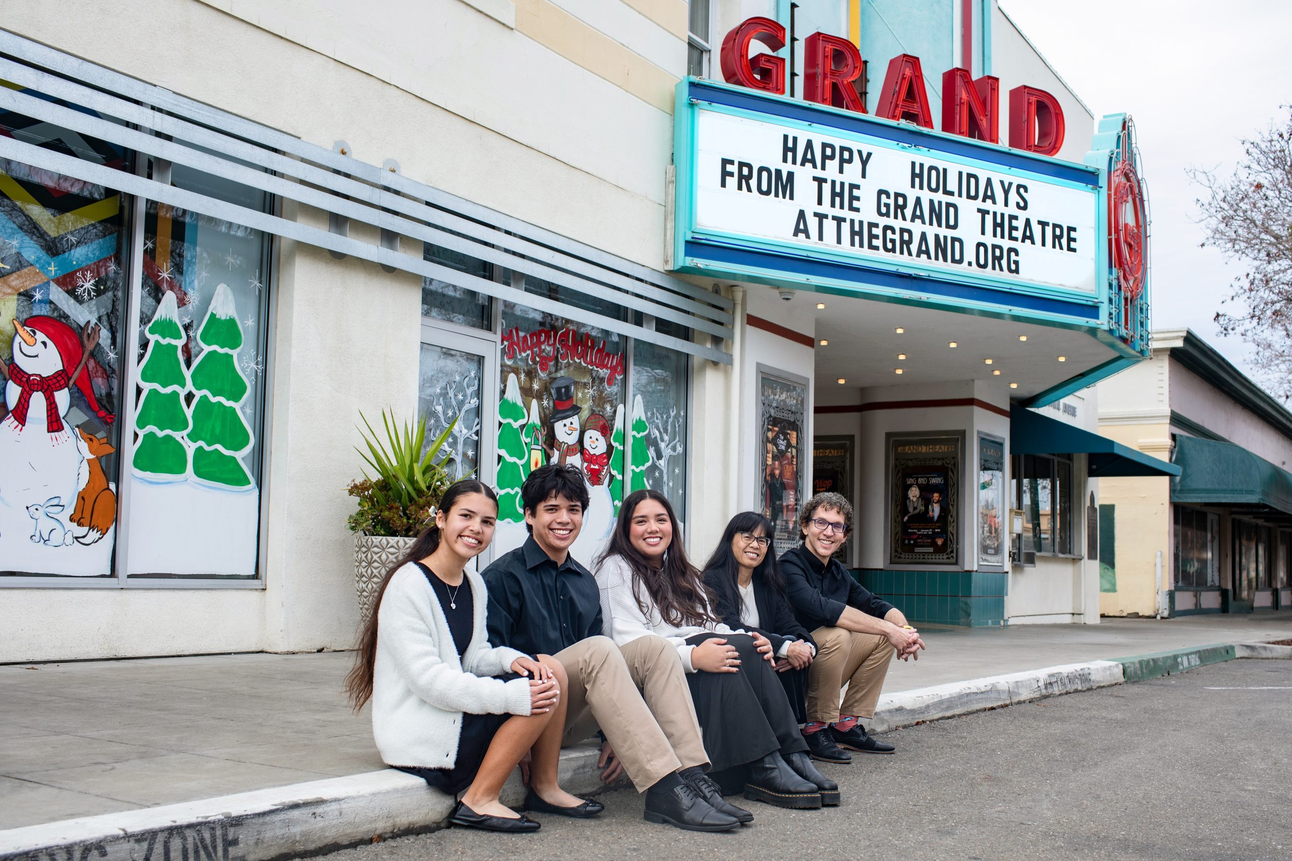 Dr Trosien and his family smiling in front of the Grand Theatre